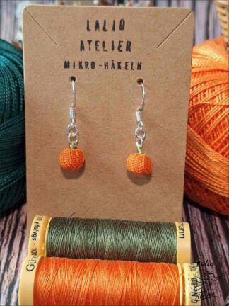 Nahaufnahme von orangen Kürbis-Ohrringen in Microcrochet Technik, nachhaltiger Herbst-Ohrschmuck