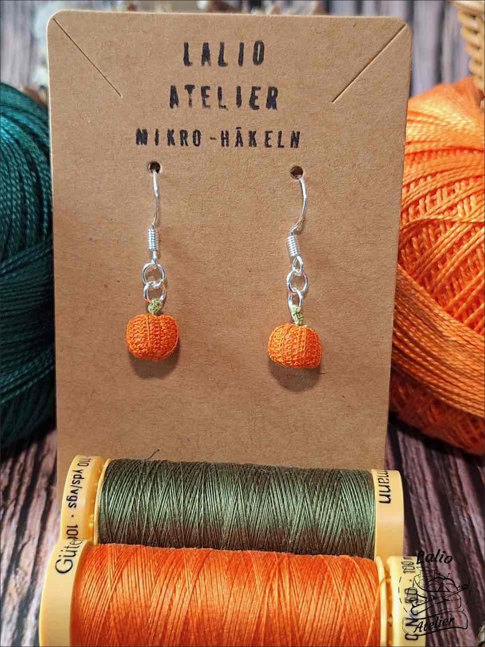 Nahaufnahme von orangen Kürbis-Ohrringen in Microcrochet Technik, nachhaltiger Herbst-Ohrschmuck