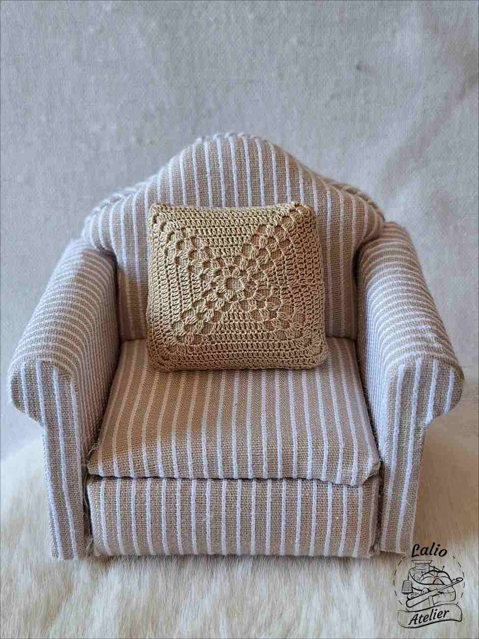 Handcrafted miniatures featuring a cushion on a miniature sofa