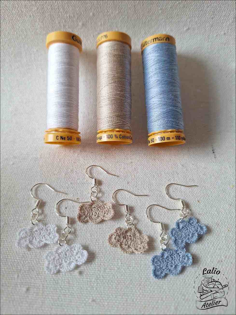 Drei Farbvarianten der gehäkelten Cloud Earrings – weiß, grau und hellblau – aus Baumwolle mit Sterlingsilber.
