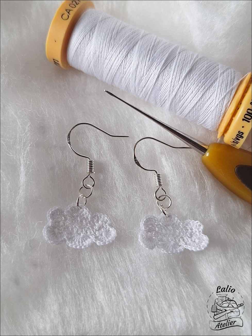 Handgemachte Microcrochet Cloud Earrings in Weiß aus 100 % Baumwolle mit 925er Sterlingsilberhaken auf neutralem Hintergrund.