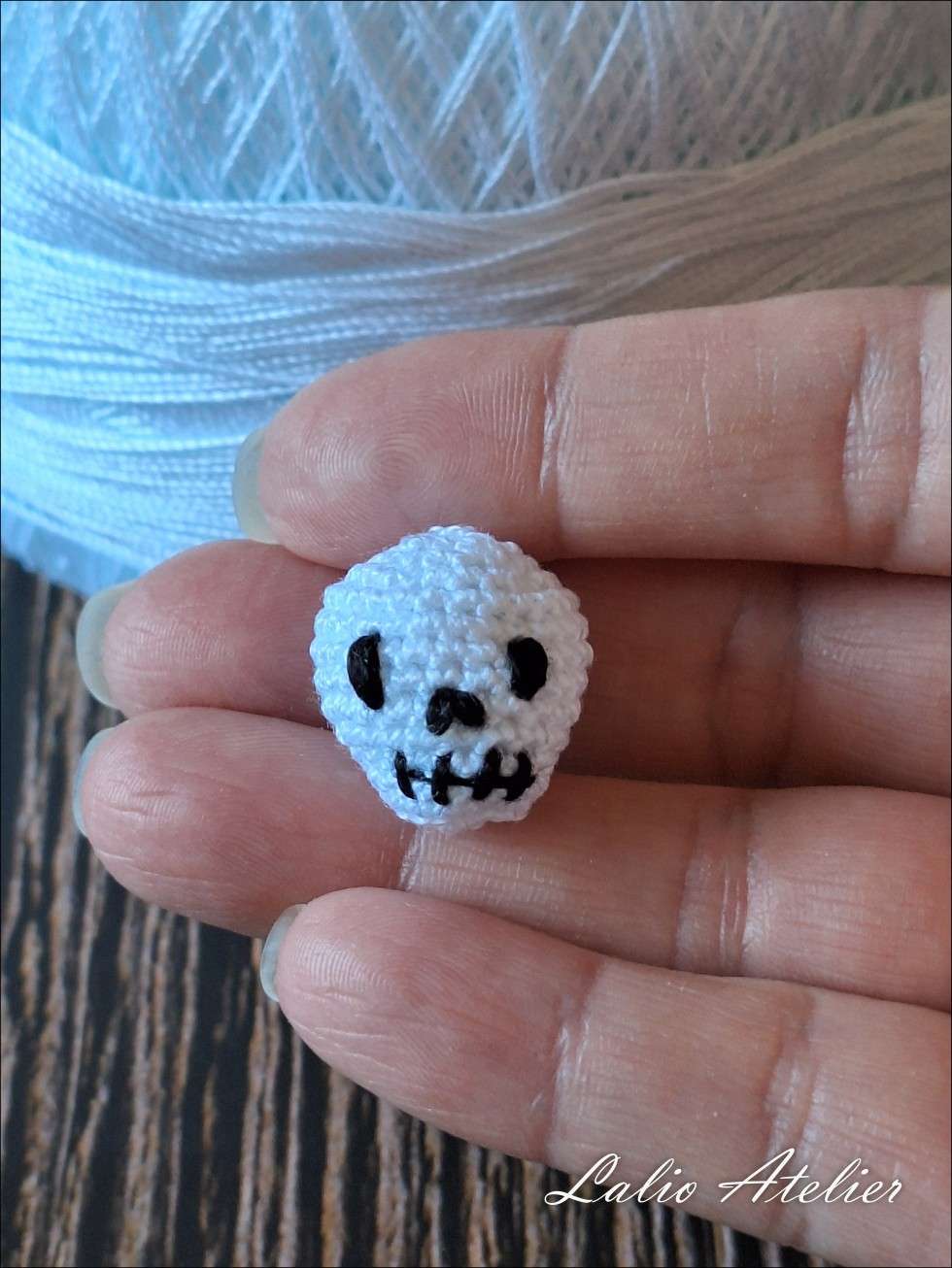 Nahaufnahme eines Microcrochet-Totenkopfs aus 100 % Baumwolle mit filigraner 3D-Struktur.