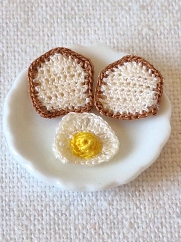 Micro crochet fried egg served on a miniature white plate